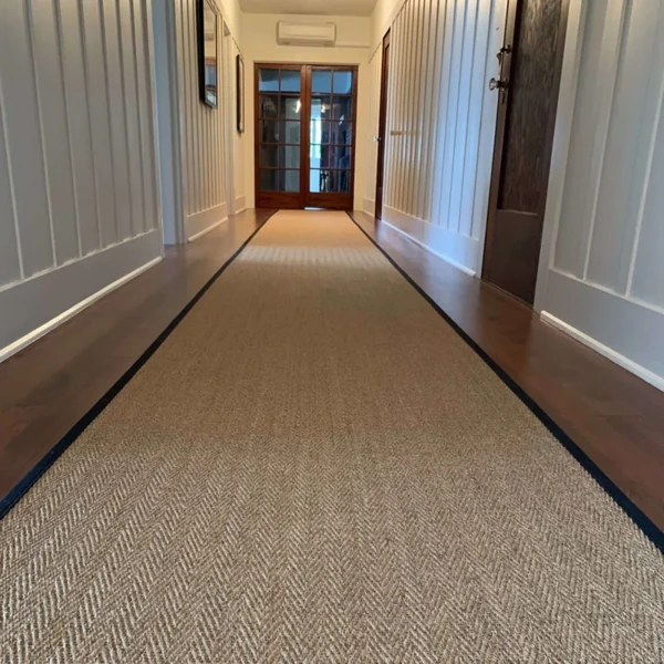 Long herringbone runner with black borders in a hall