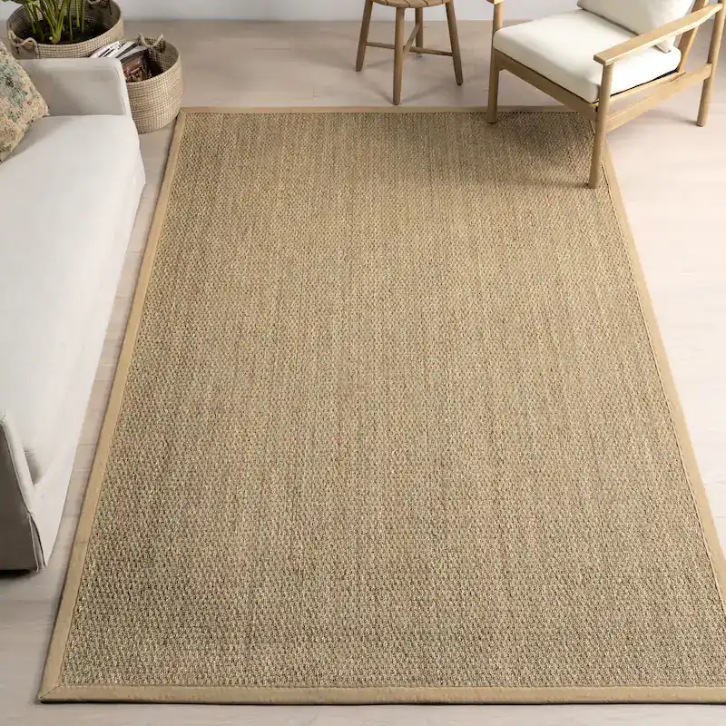 Tan woven area rug with a fabric border